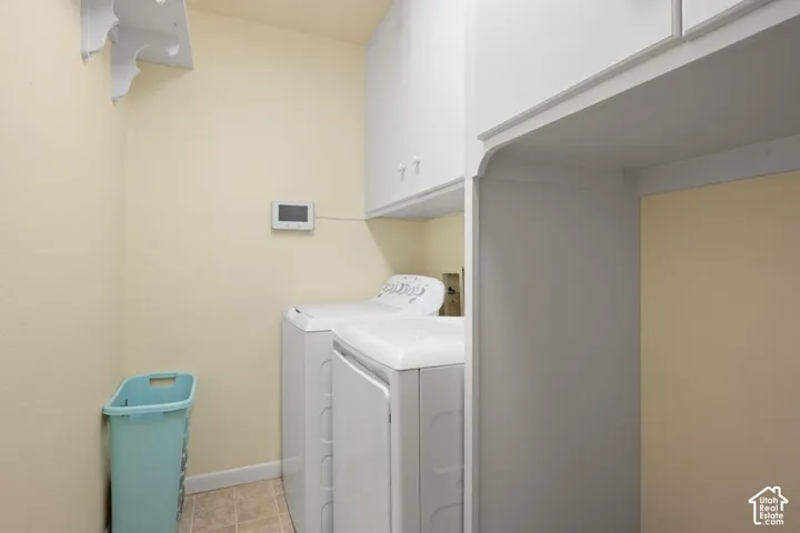 Utility area featuring overhead white cabinetry and a mounted wall shelf