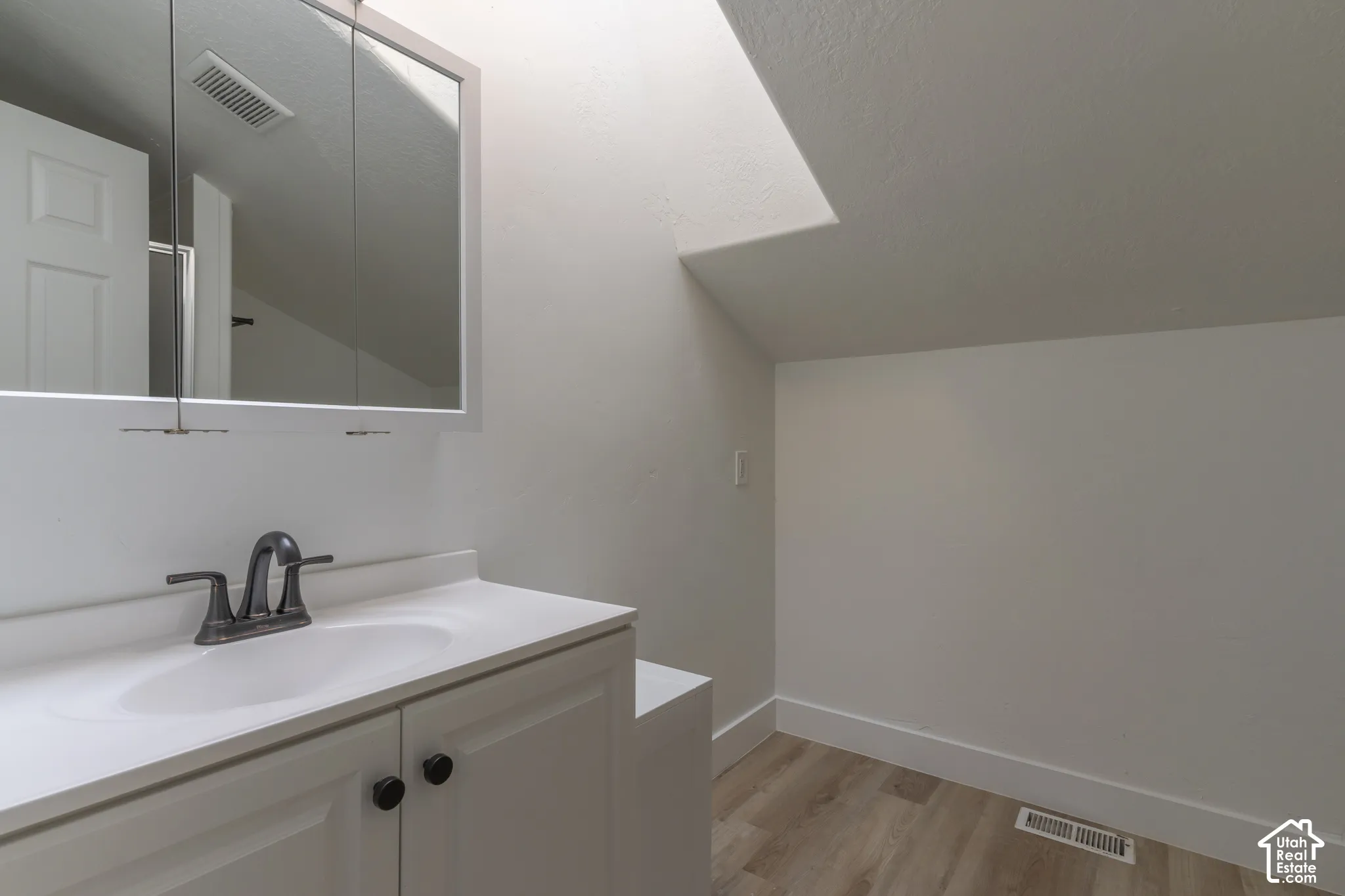 Second floor bathroom with new LVP, cabinetry, and fixtures.