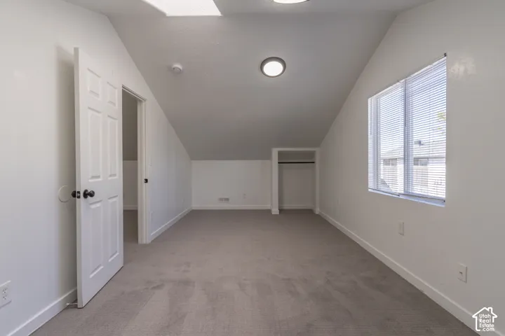 Second floor bedroom with vaulted ceilings, a built-in skylight, and new carpet