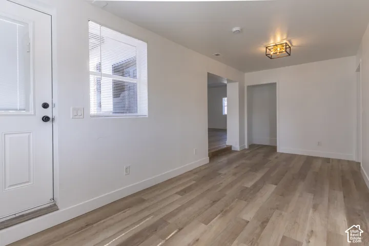 Oversized entry with new LVP and lighting. View looking into main floor family room