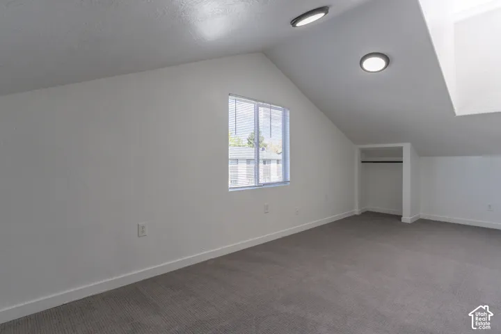 Second floor bedroom with vaulted ceilings, a built-in skylight, and new carpet