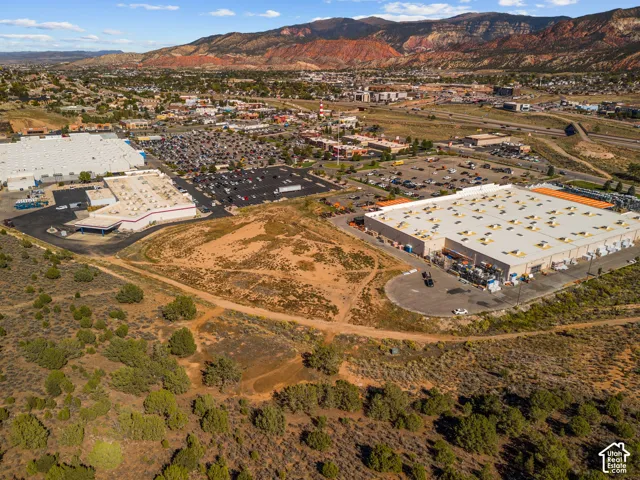 Aerial perspective of expansive vacant land featuring native desert vegetation, natural terrain, and prominent mountain backdrops