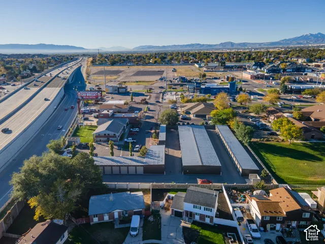 Aerial perspective of multi-unit storage facility featuring metal roofing, paved drive aisles, perimeter fencing, and mountain backdrop