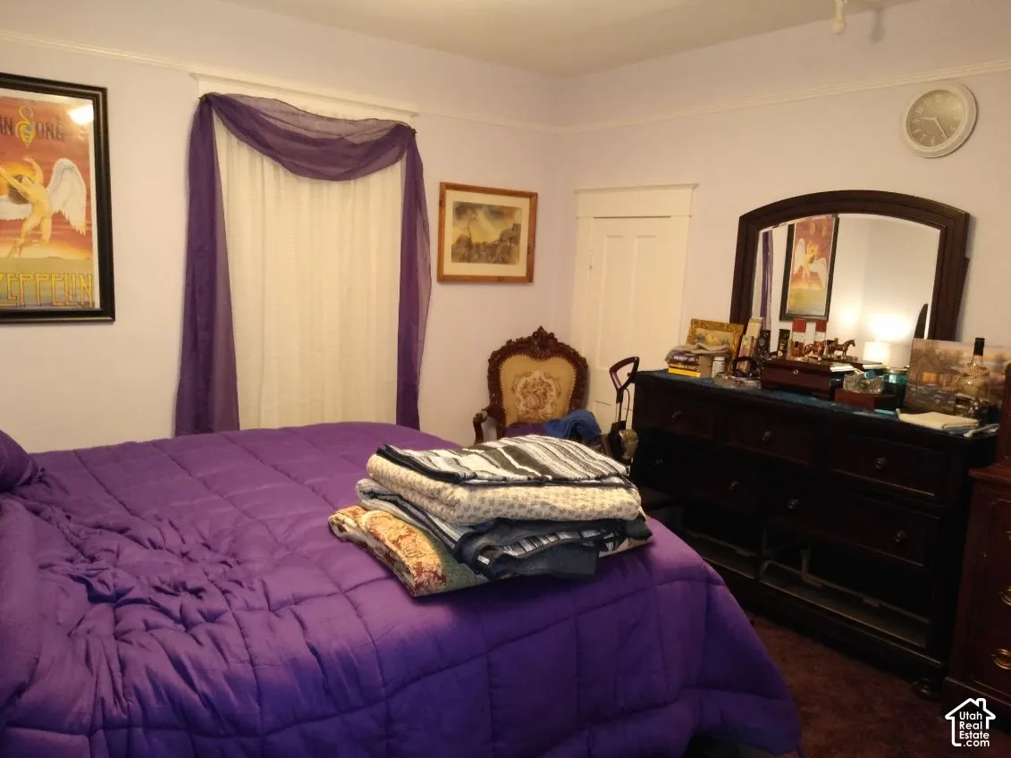 Interior room featuring crown molding, a multi-panel door with architectural casing, and carpeted flooring