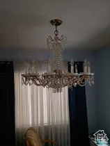 Multi-tiered crystal chandelier with intricate metal detailing and candelabra-style light fixtures