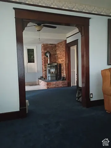 Stained wood doorway casing with ornamental corbels, exposed brick chimney, and hearth-mounted stove