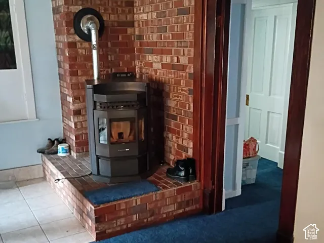 Floor-to-ceiling brick surround featuring a built-in stove and raised hearth with natural tile accent