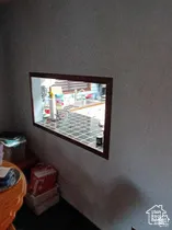 Interior wall cutout featuring dark wood trim and a tiled serving counter