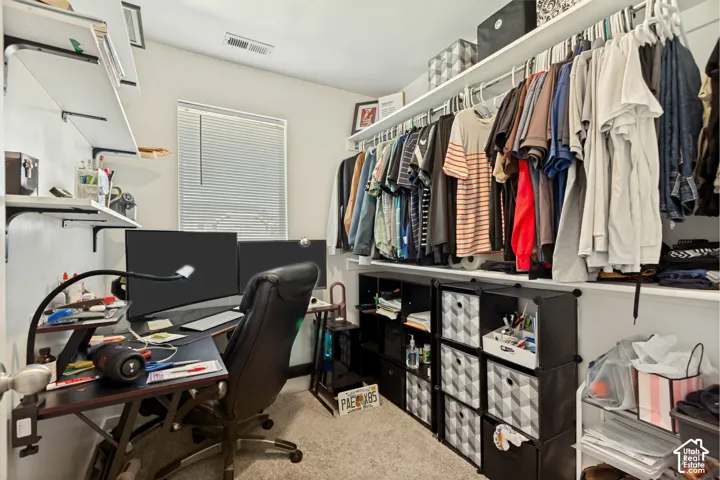 Walk-in closet featuring wall-to-wall shelving, integrated garment rods, and carpeted flooring