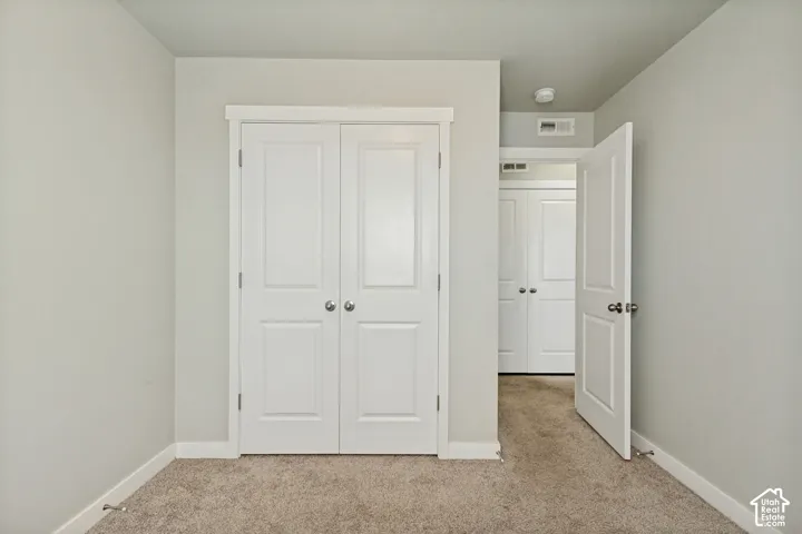Neutral wall paint, neutral carpeting, and white interior doors with satin nickel hardware