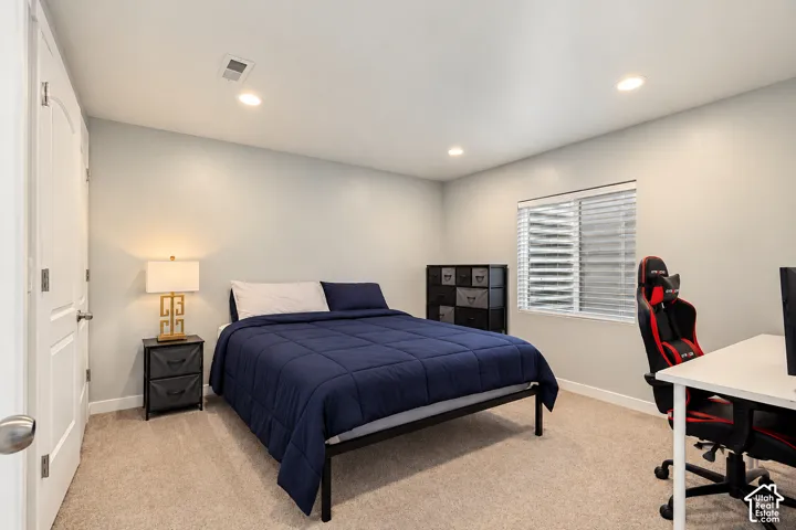 Neutral-toned interior featuring plush carpeting, recessed lighting, and a multi-panel door