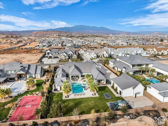 Expansive rear grounds featuring a swimming pool, integrated spa, manicured lawn, and perimeter hardscaping