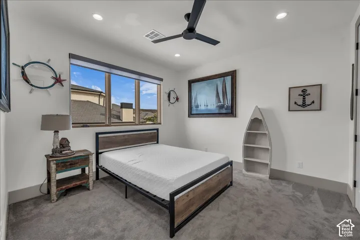 Room featuring neutral-toned carpeting, recessed ceiling lighting, a matte black contemporary ceiling fan, and large windows with minimalist trim