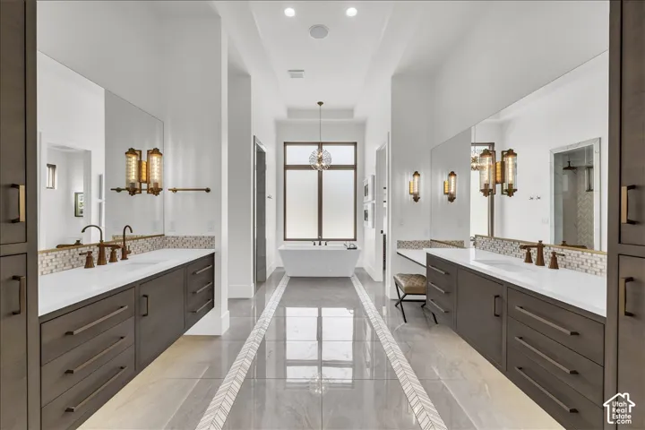 Dual vanities featuring dark cabinetry, solid-surface countertops, and bronze-tone hardware