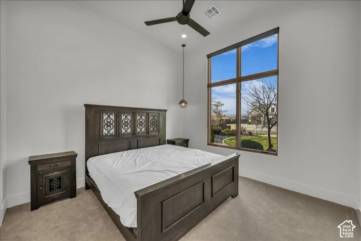 High ceilings featuring a matte black ceiling fan, expansive multi-pane window, and a modern pendant light fixture