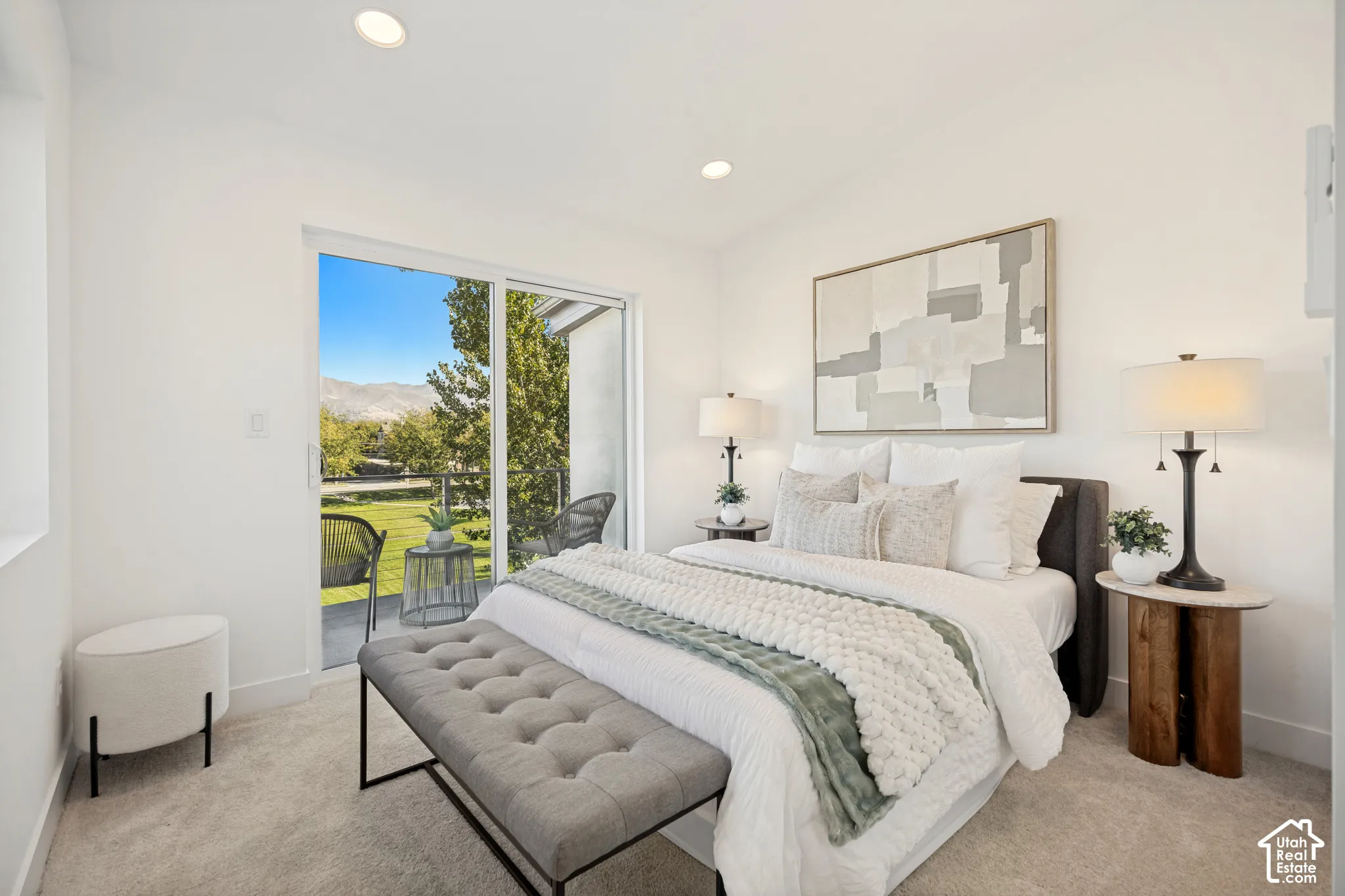Bedroom featuring neutral wall-to-wall carpeting, recessed lighting, and a sliding glass door with a mountain backdrop