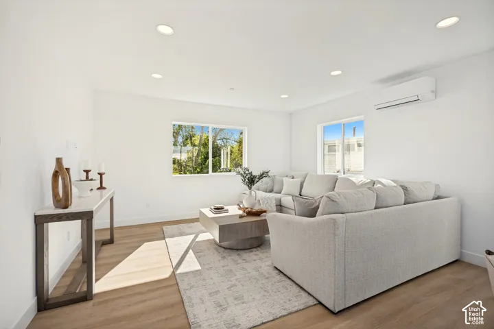 Interior space featuring wood-finish flooring, recessed lighting, dual sliding windows, and a wall-mounted ductless climate control unit
