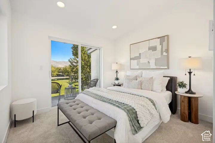 Bedroom featuring neutral wall-to-wall carpeting, recessed lighting, and a sliding glass door with a mountain backdrop
