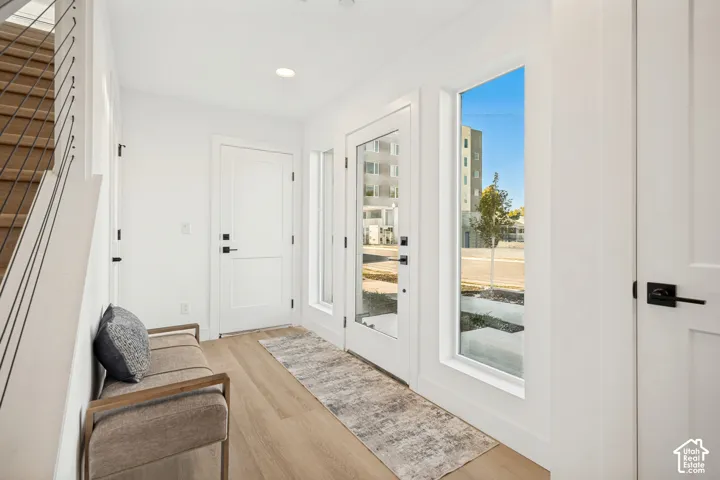 Entryway featuring wood-finish flooring, floor-to-ceiling windows, modern cable railing, matte black hardware, and recessed lighting
