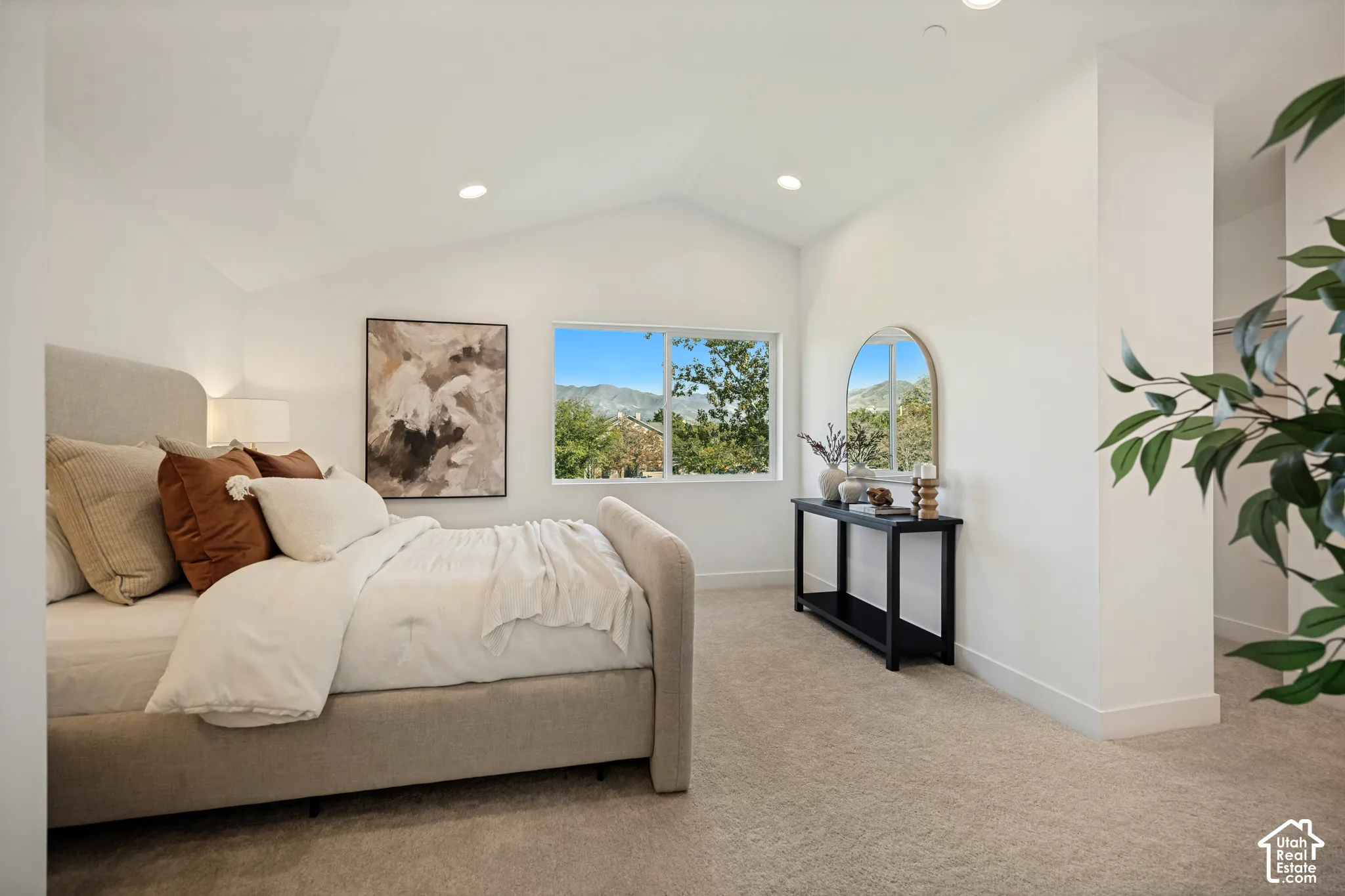 Vaulted ceiling, neutral carpeted flooring, recessed lighting, and a large window featuring mountain scenery