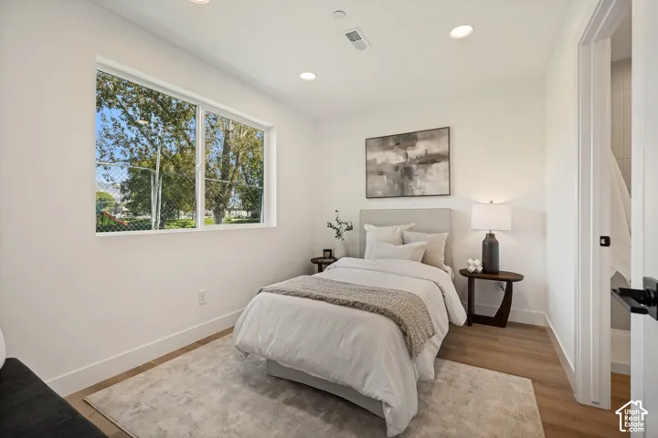 Bright room featuring wood-finish flooring, recessed lighting, and a large horizontal sliding window