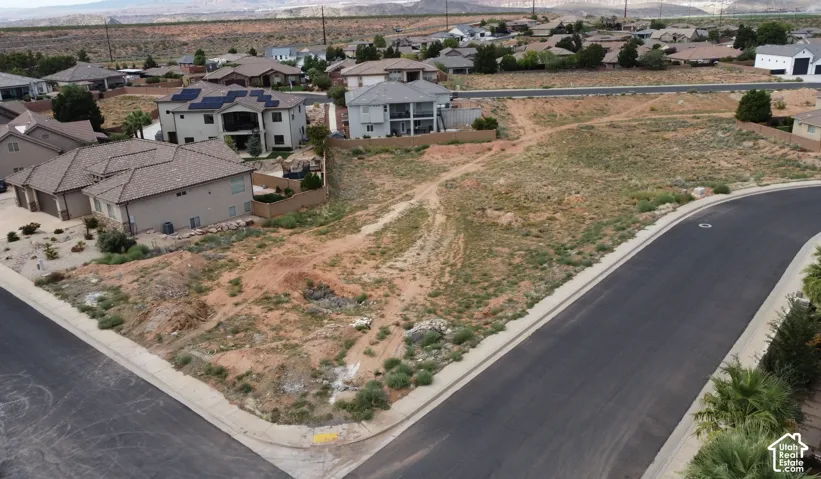 Corner lot featuring desert topography, asphalt street access, and mountain backdrop