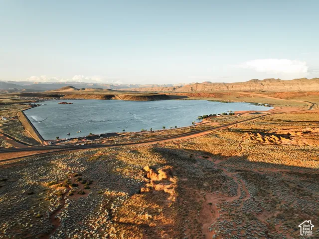 Aerial perspective of a high-desert landscape featuring a reservoir, expansive natural terrain, and prominent mountain backdrops