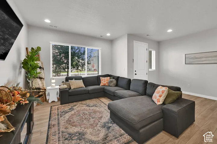 Neutral interior featuring wood-finish flooring, recessed lighting, and a multi-pane window