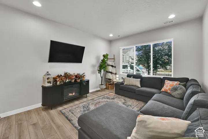 Living area featuring wood-finish flooring, recessed lighting, and a large multi-pane window