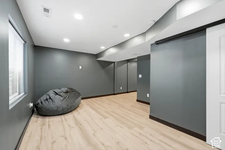 Recessed lighting, wood-finish flooring, and a white sliding barn door