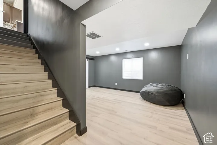 Light wood-finish flooring throughout the room and staircase