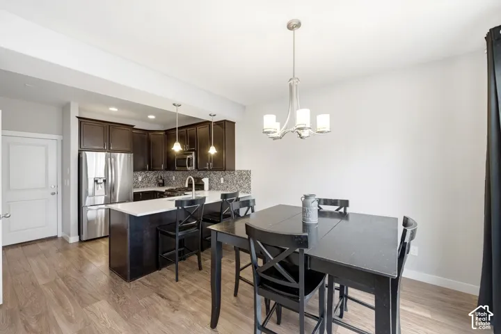 Wood-finish flooring, dark wood cabinetry, and stainless steel appliances