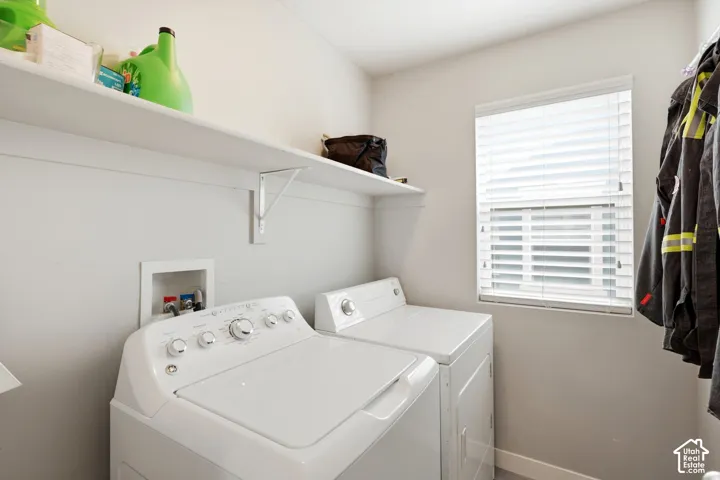 Laundry area featuring built-in shelving, a window with blinds, and white walls