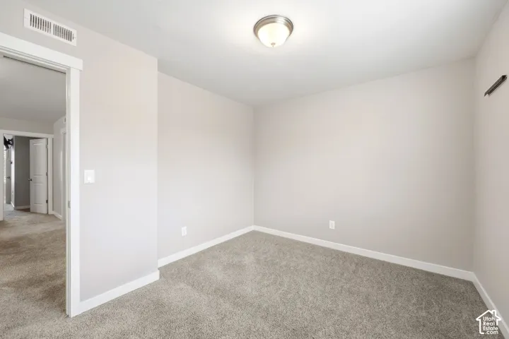 Carpeted flooring, neutral wall tones, flush-mount ceiling light, white trim, and a white interior door