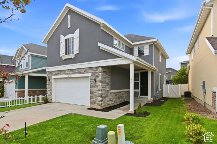 Stucco exterior with stone accent, covered entry, and attached garage