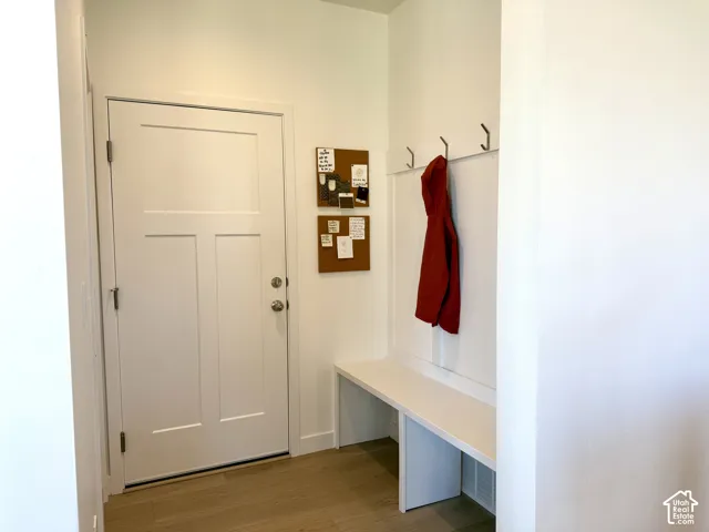 Wood-finish flooring with a built-in bench and wall-mounted hooks