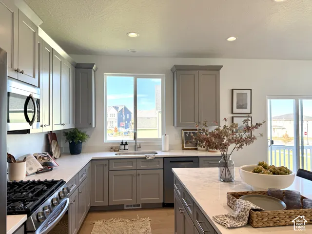 Kitchen featuring recessed lighting, a stainless steel gas range, built-in microwave, and a window above the sink