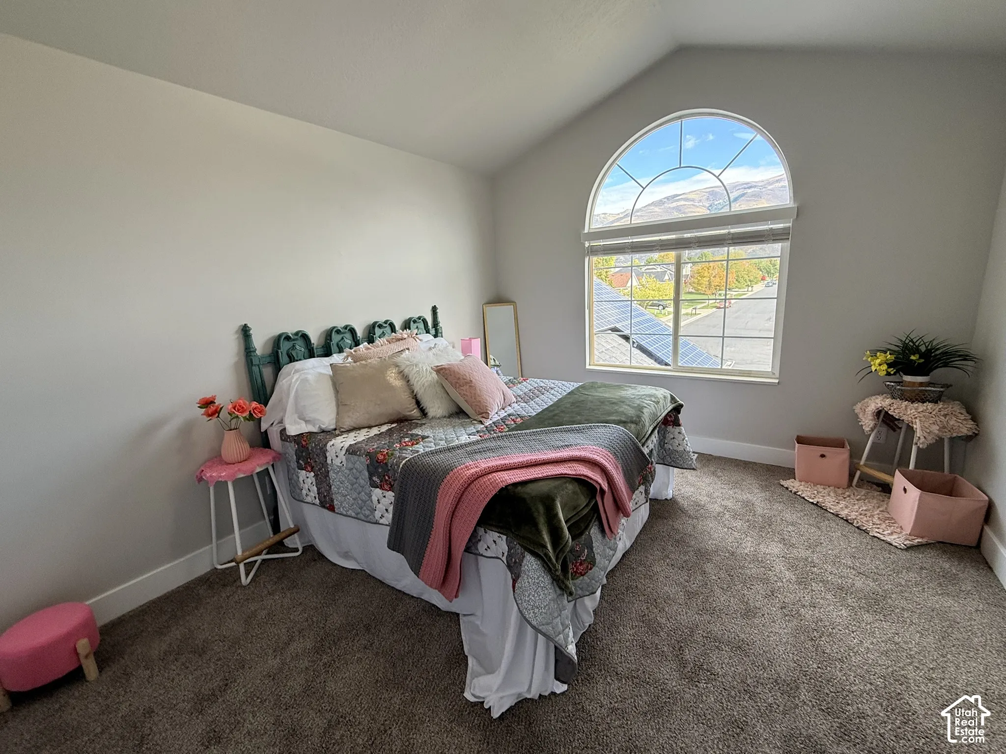Vaulted ceilings, neutral wall tones, wall-to-wall carpeting, and an arched window featuring mountain scenery