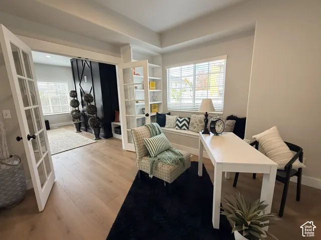 Wood-finish flooring, built-in shelving, glass-paneled French doors, and a built-in window bench