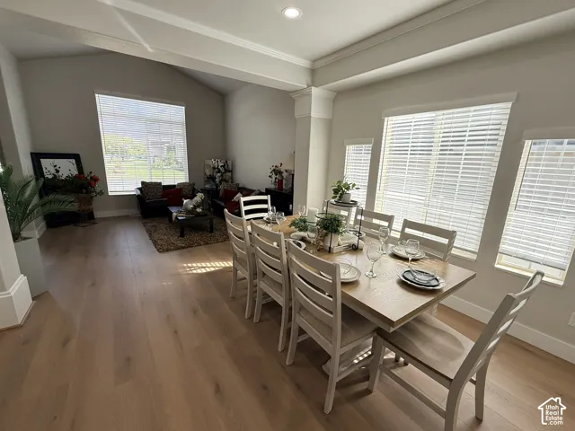Vaulted ceilings, wood-finish flooring, recessed lighting, and multiple oversized windows with horizontal blinds