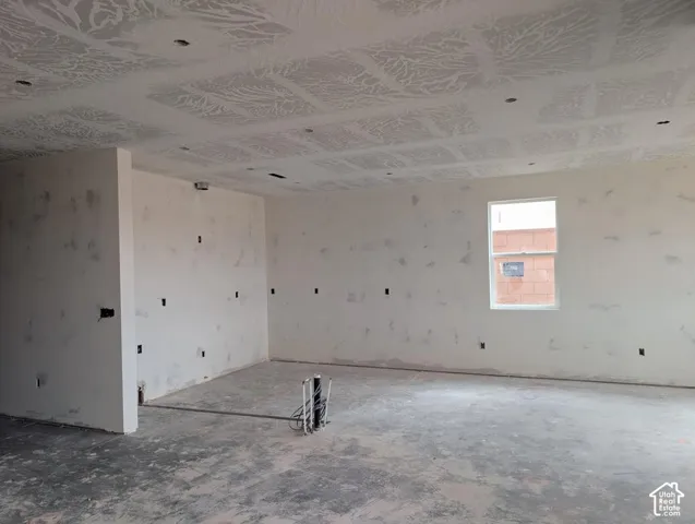 Open-concept interior featuring textured ceiling detailing, recessed lighting, and a single-pane window