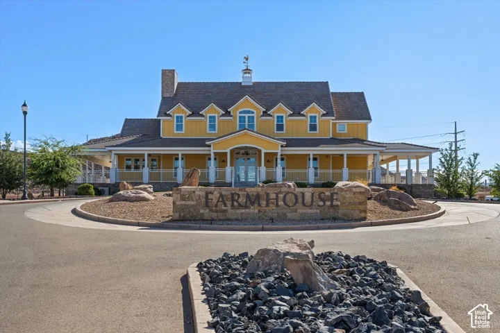 Farmhouse-style exterior featuring vertical siding, multiple dormer windows, a wrap-around porch, and a central cupola