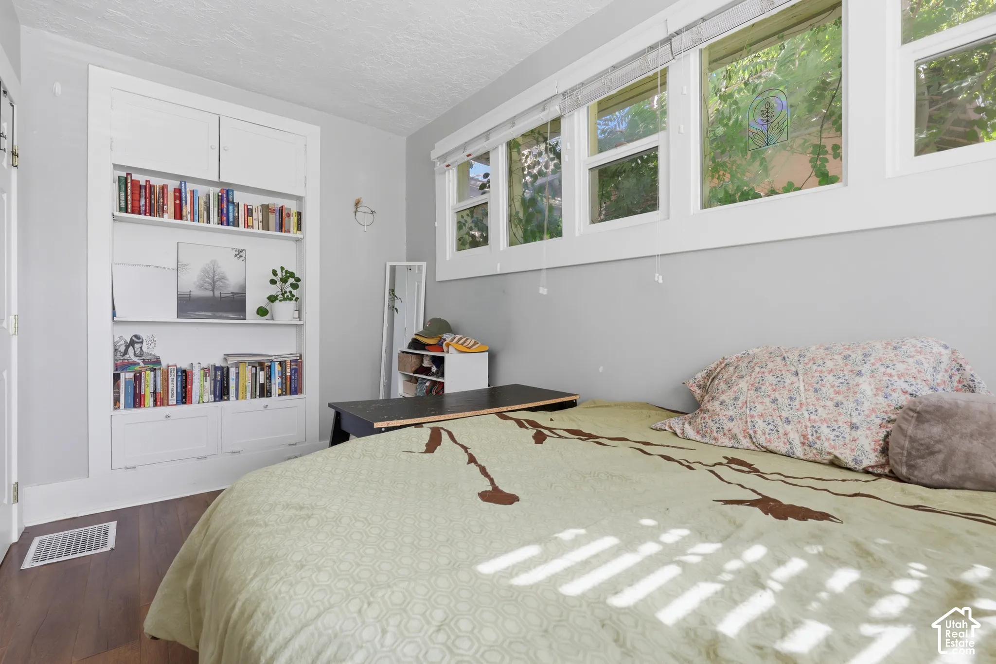 Built-in white wall shelving with lower cabinetry and multiple window panels featuring white trim