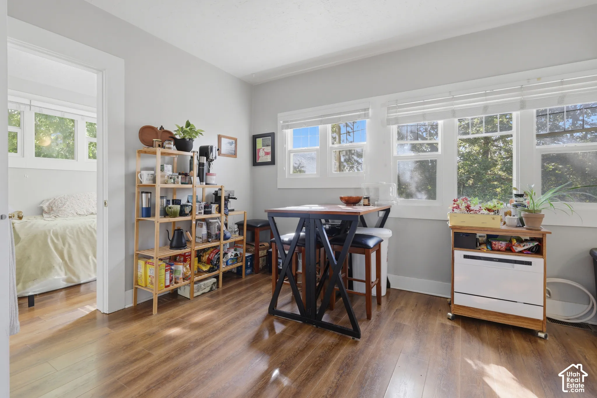 Wood-finish flooring, multi-pane windows with horizontal blinds, and neutral wall tones