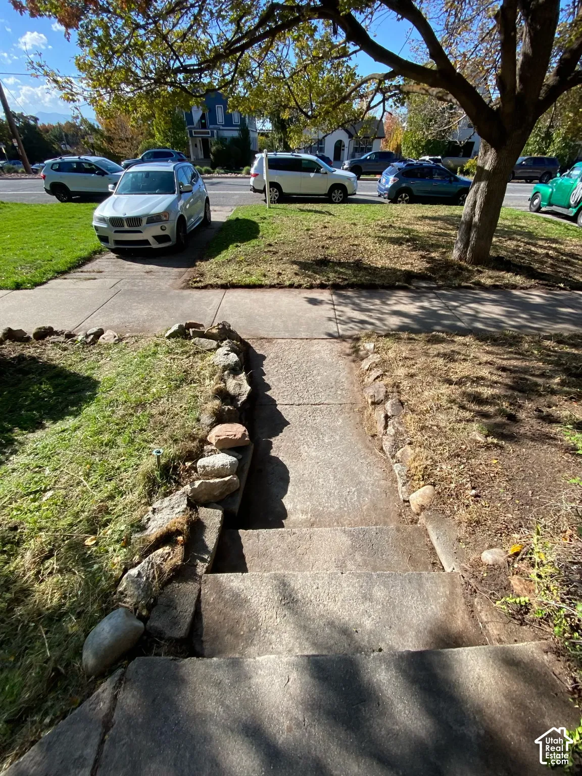 Concrete exterior stairs featuring natural stone edging and a paved walkway