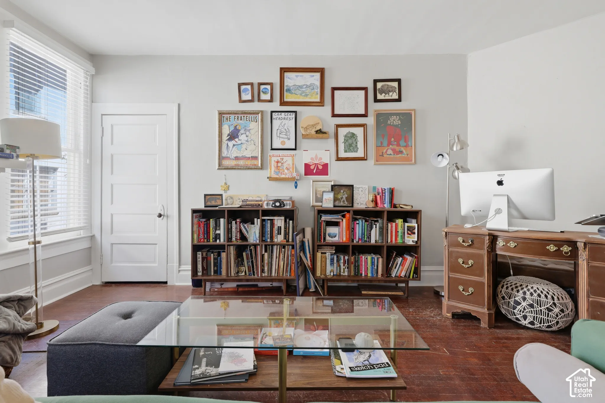 Room featuring original hardwood flooring, a multi-panel interior door, and a tall window with horizontal blinds