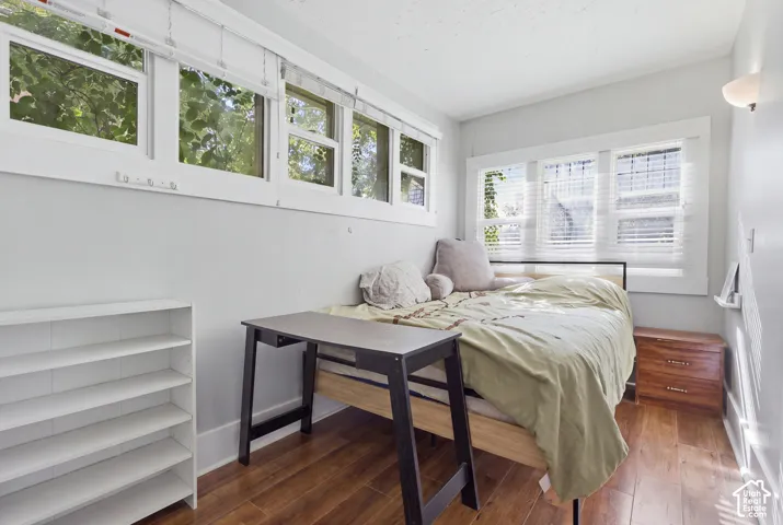 Multi-pane windows with white trim, wood-finish flooring, and wall-mounted lighting