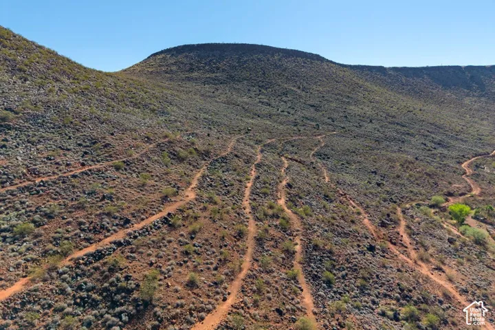 Expansive hillside terrain featuring natural rock formations, native vegetation, and established dirt trails