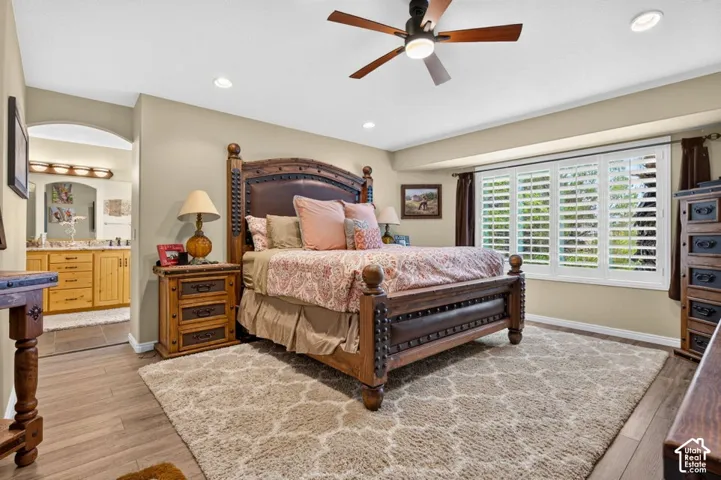 Room featuring wood-finish flooring, recessed lighting, a ceiling fan with integrated lighting, and plantation shutters