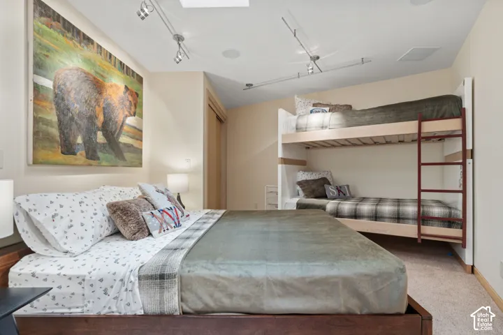 Built-in bunk bed, adjustable ceiling-mounted track lighting, recessed ceiling speakers, and wall-to-wall carpeting